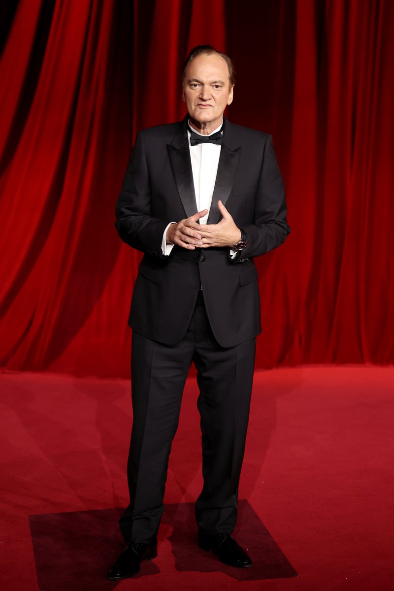 Dior's tweet photo. Impeccably defined.
Quentin Tarantino moved through the 2024 Academy Museum Gala, clad in a Dior Men's collection tuxedo by Kim Jones—bold black wool and silk with a white shirt and a silk bow tie—completed with leather derbies and a polished finish from Dior Beauty.
#StarsinDior https://t.co/do0GOWzQh6