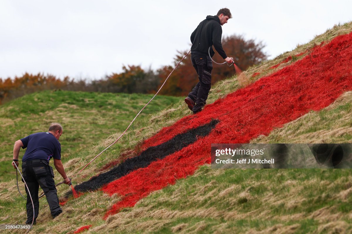 Staff from the Scottish Rugby Union paint 30ft red poppies across the grass pyramids on the side of the M8, near Bathgate in honour of the #PoppyAppeal ahead of #RemembranceDay in Scotland. I October 23, 2024 I 📷:  Jeff J Mitchell #GettyNews