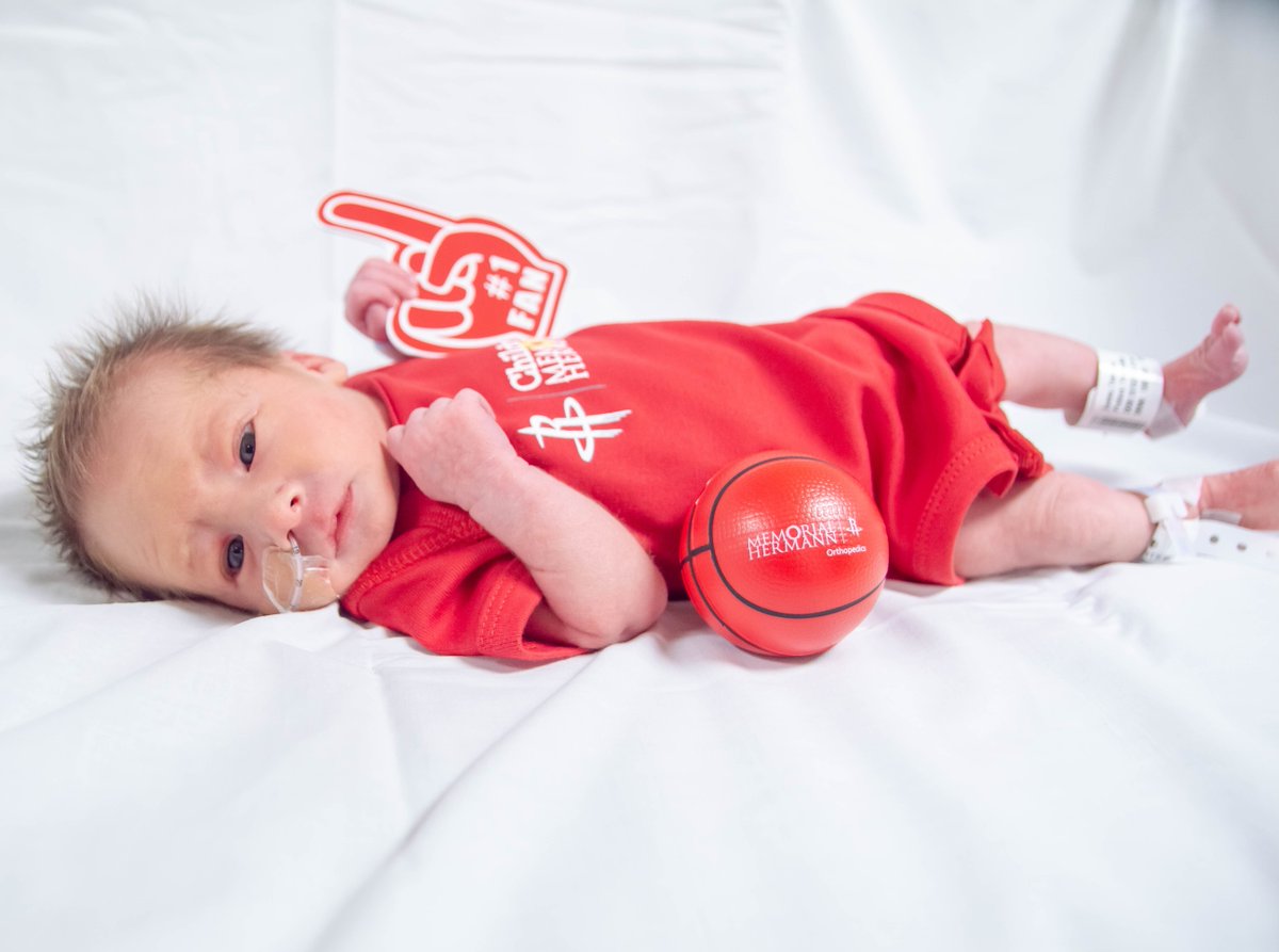 An infant patient from the Children's Memorial Hermann Hospital Neonatal Intensive Care Unit wears a Houston Rockets onesie in support of the basketball team.