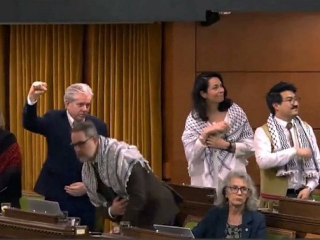 TomTSEC's tweet photo. Here is a picture of the Islamist terrorist who killed a Canadian Forces soldier and attacked the Canadian Parliament ten years ago.

Here also is a picture of three NDP MPs in Parliament in the last year.

Do you notice any similarities between them?  Maybe something in the symbology department?