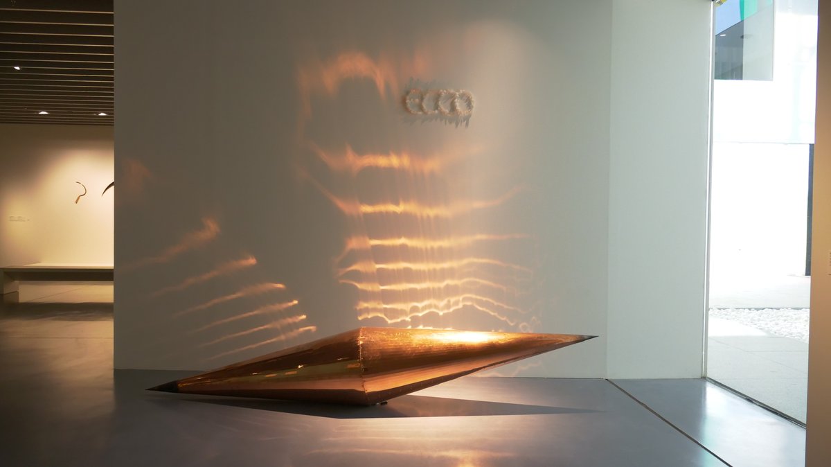 Ven a conocer 'Place-ness'. 😍
Hoy destacamos 'Echo-Ecco' (1984) de François Bouillon. El elemento cónico de cobre (Echo) se presenta iluminado de manera que el reflejo generado apunta hacia la palabra Ecco, mientras que una línea de carboncillo marca la sombra en el suelo.