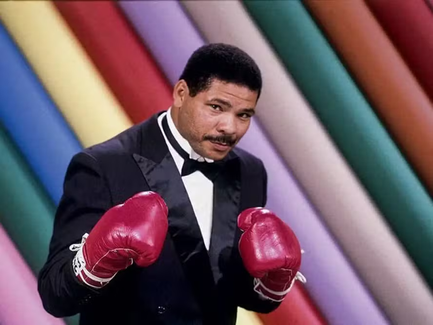 naodanossaconta's tweet photo. Não é da nossa conta, mas vamos opinar mesmo assim sobre Maguila 🥊, o #boxeador, foi o tipo de cara que entrava no #ringue como se estivesse indo pra uma feira 🛒, só que em vez de comprar frutas 🍌🍎, ele distribuía #socos! 🥊✨ Maguila não era só um #atleta; ele era praticamente um showman 🎤, um verdadeiro entertainer do #pugilismo. Imagina você, lá no canto do sofá 🛋️, vendo aquele gigante gentil 😇, com um sorriso que parecia dizer "Vou te nocautear, mas te ajudo a levantar depois" 😄🤜🤛.
#Maguila, ou José Adilson Rodrigues dos Santos 👀, se você quiser chamar pelo nome completo como se fosse sua mãe brava 😡, foi um fenômeno dos anos 80 e 90 📅. O cara começou a carreira numa época que o #Brasil precisava de heróis fora das novelas 📺 e do futebol ⚽. E ele veio com tudo, batendo e apanhando 💥, mas sempre com aquele carisma que fazia você torcer por ele mesmo se você não soubesse a diferença entre um jab e um cruzado 🤷♂️.
Sua vida? Ah, foi um verdadeiro roteiro de filme 🎬. Veio do nada, do sertão de Sergipe 🌵, pra se tornar um dos pesos pesados mais conhecidos do Brasil 🇧🇷. E não estamos falando de peso pesado só no ringue; o cara tinha presença 💪, um coração que parecia maior que o próprio corpo ❤️. Maguila enfrentou gigantes, literalmente, como o Evander Holyfield 🥇, e mesmo quando não ganhava, saía do ringue com mais fãs do que entrou 👏👏.
Mas vamos falar do legado do nosso querido Maguila 🔥. Ele não deixou só cinturões 🏆 e recordes 📊; deixou histórias, risadas 😂 e uma lição de que você pode ser duro na queda 💪, mas doce na vida 🍬. Sua #morte? Foi como se o Brasil perdesse um tio engraçado 😂👴 que sempre tinha uma história boa pra contar nas festas de família 🎉.
E os emojis? Bom, se Maguila fosse um emoji, ele seria aquele soco 👊 com uma carinha sorrindo 😄, porque ele sabia bater com amor 💓. Ele foi um lutador que mostrou que no esporte 🏅, como na vida, você pode ser forte 💥 e ainda assim ser amado 🥰. E se tem uma coisa que Maguila fez foi encher nossa vida de momentos que merecem ser celebrados com um levantamento de luvas 🥊❤️.
Então, aqui vai um brinde 🍻 ao Maguila, que mesmo não estando mais entre nós, continua a nos ensinar que a vida é um ringue 🥊, onde o importante não é só vencer 🏆, mas lutar com alegria 😁 e sair de lá aplaudido 👏, mesmo que seja pelos adversários 🤝. Vida longa ao legado do gigante de #Sergipe! 💫
Gostou? Curte, comenta e compartilha.