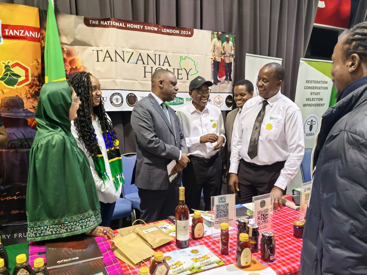 UbaloziUK's tweet photo. Asali ya Tanzania - Swahili honey, Go Green honey,  na Miombo yawa kivutio katika maonesho ya Asali yaliyoanza jana jijini London.  Imeelezwa kwamba kuanzia mwezi January 2025 asali hiyo itaanza kuuzwa katika maduka makubwa nchini Uingereza. Balozi @MbelwaK ametembelea maoenesho hayo leo na kutoa pongezi kwa Makampuni ya PMM, African Group, Central Park Bees na FREMU kwa kuchangamkia soko la Uingereza na amewaahidi ushirikiano wa Ubalozi katika kutafuta masoko mapya