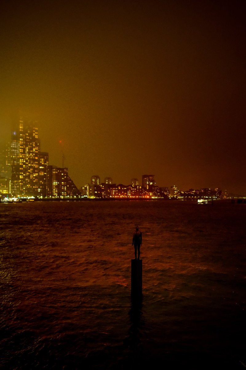 Play misty for me. The tower blocks of Canary Wharf disappearing into the mist, as an Anthony Gormley statue stands in the Thames, watching.