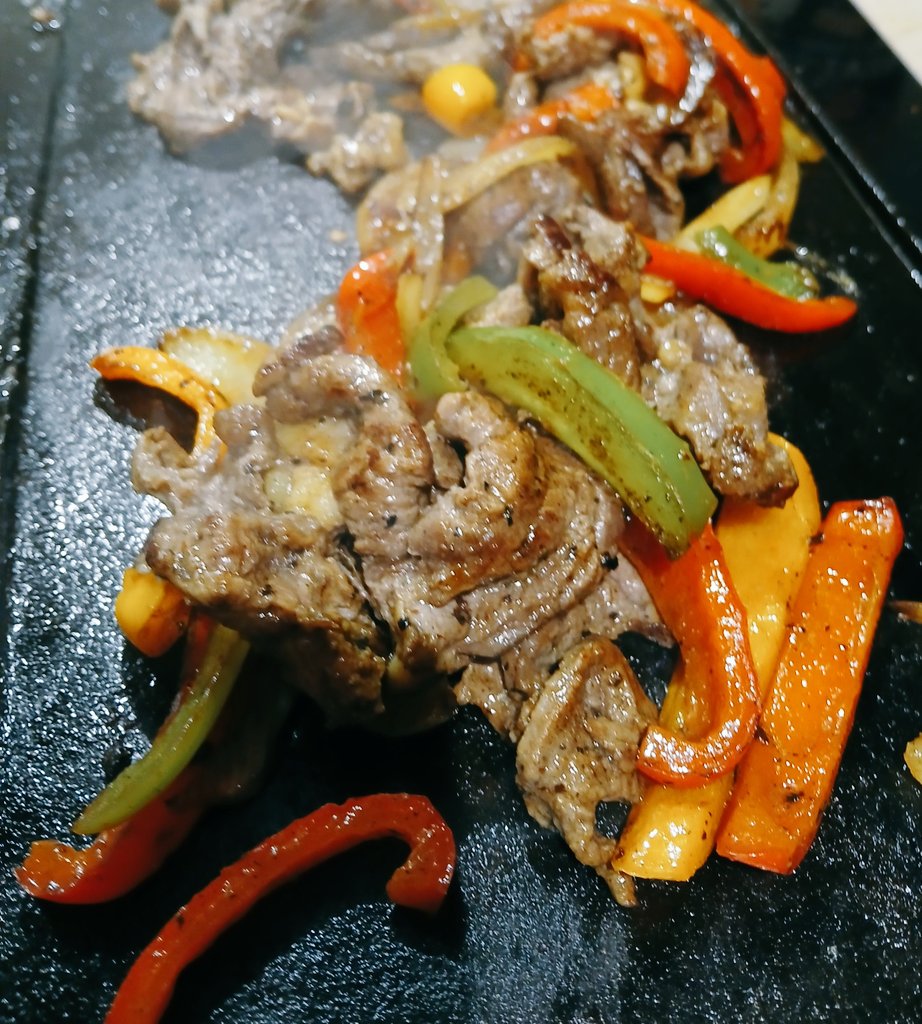 Dünn geschnittenes Rindfleisch mit Knoblauch und schwarzem Pfeffer von der Bratplatte mit Paprika und Zwiebeln, serviert auf gebackener Süßkartoffel.
Essen, jetze*!

*Gestern