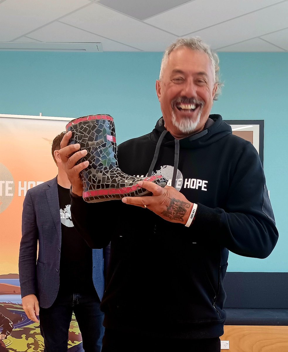 thekiwicanary's tweet photo. Mike King holds the concrete mosaic red band gumboot that mum made and donated as a prize to raise funds for youth mental health. He drew the winning ticket out this morning at a work breakfast with a colleague at Huntly Power Station winning the item. $387 raised #gumbootfriday https://t.co/oUuEndhiZg