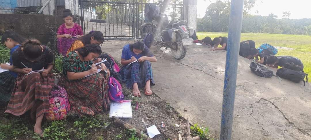 Maestro atiende a alumnos fuera del edificio escolar, porque la directora se fue a la asamblea que convocó hoy el STEG, sindicato que dirige Joviel Acevedo. 
La directora es quien porta  llaves del portón de la escuela.
Hay miles de maestros en toda Guatemala, que resisten.