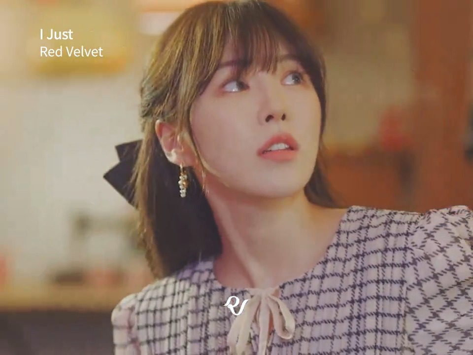 A young woman with short brown hair wearing a pink and white checkered top looks upward, with text reading 'I Just Red Velvet' and a logo in the corner.
