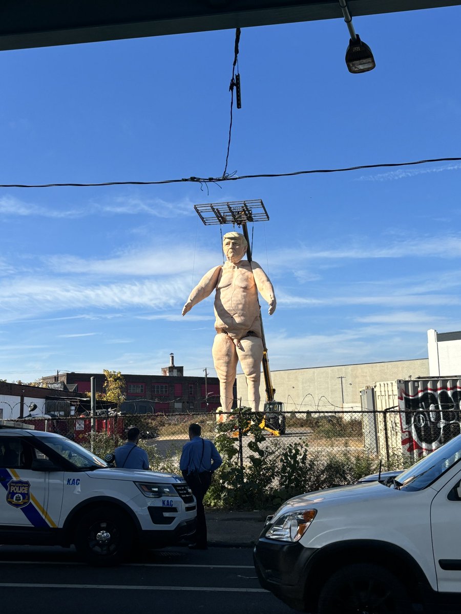 Someone has constructed a naked 50 ft statue of Donald Trump on Kensington Ave in Philly. Big police presence here.