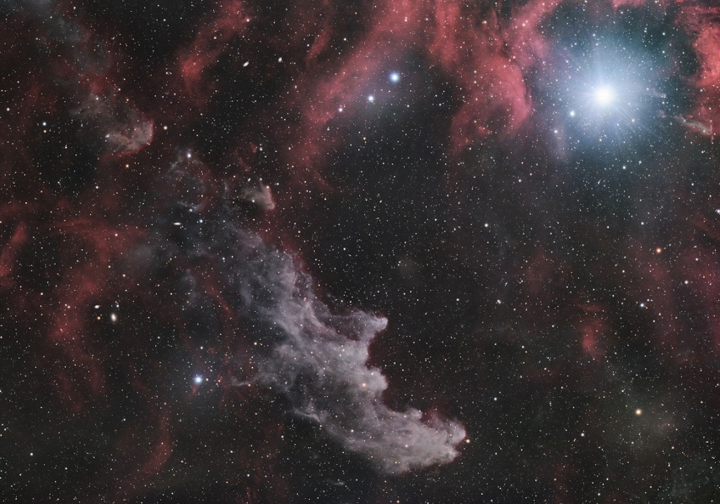By starlight, this eerie visage shines in the dark with a crooked profile evoking its popular name, the Witch Head Nebula. In fact, this entrancing telescopic portrait gives the impression that a witch has fixed her gaze on Orion's bright supergiant star Rigel. More formally