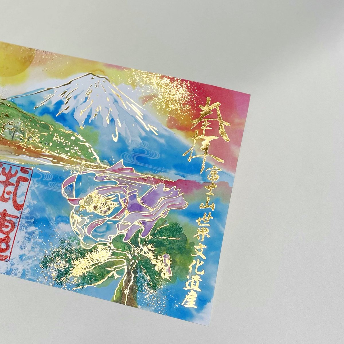 murata_kimpaku's tweet photo. 「富士山と天女」をテーマにした御朱印への箔あしらい🗻✨
今回のデザインは華やかで優しい水彩色をメインに彩ったため、箔はシンプルな金色の箔であしらいました���️
#村田金箔
#御朱印
#foildesign https://t.co/aDYkmowil9