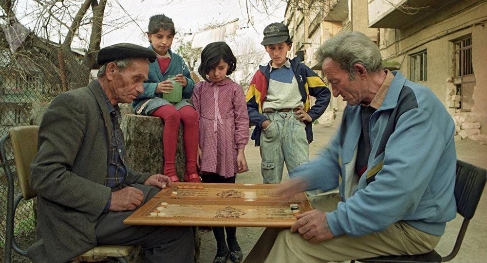 Local residents playing backgammon in a courtyard in Yerevan. Armenia, 1993.