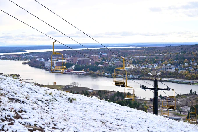 Michigan Tech's Mont Ripley ski hill is covered in a light dusting of snow. The Husky chairlift, the Portage Canal and Michigan Tech's campus is seen in the distance.