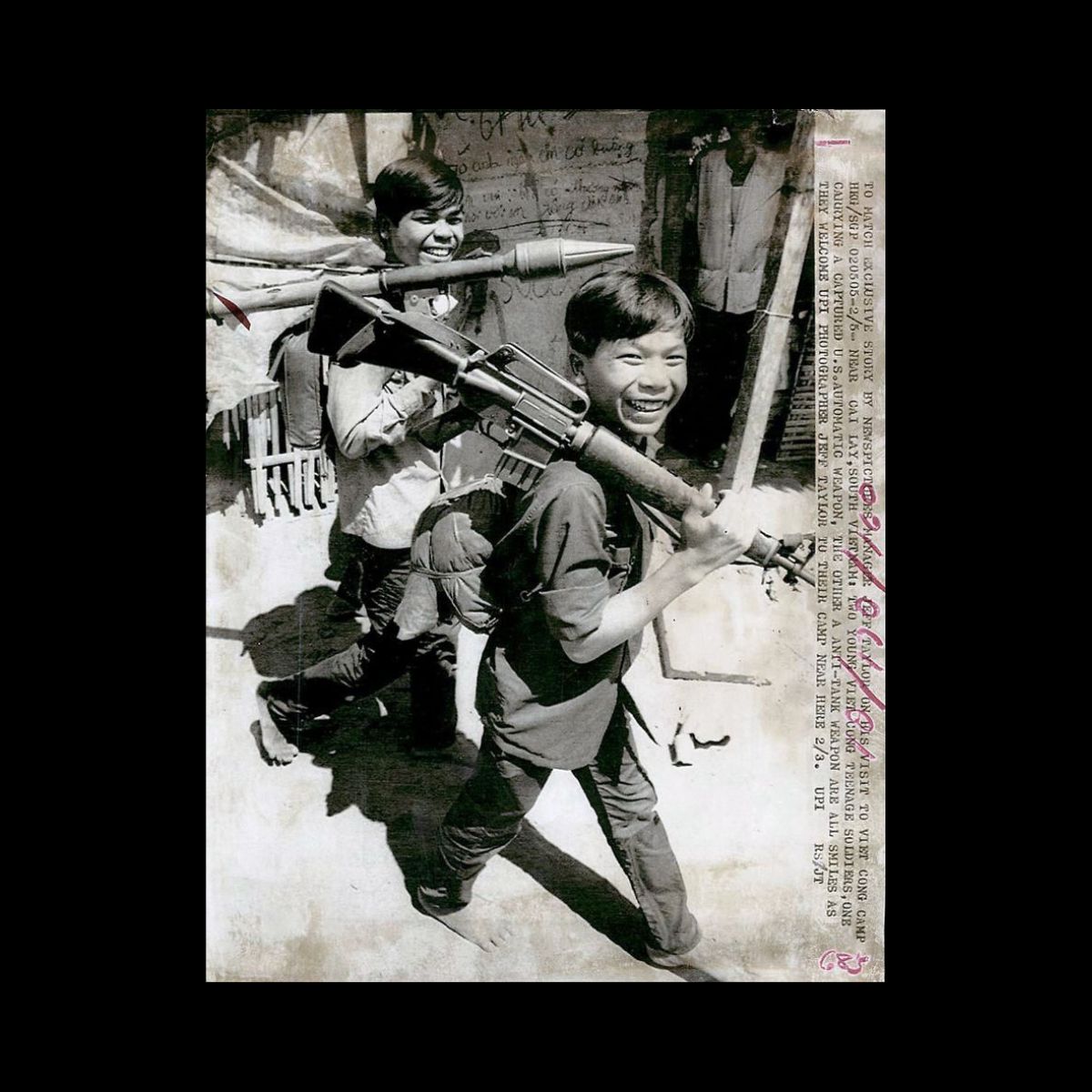 2 young V.C soldiers one with a American M-16 smile for the camera.