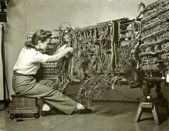A photo of an engineer wiring an early IBM computer, 1958.