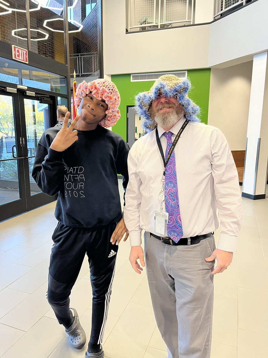 HMC1_RWLC's tweet photo. Our principal taking a quick break from meetings to show off his style! Suspenders game strong, floppy knit hat on point, and the student’s got the look too. Fashion vibes are on point today! #PrincipalStyle @HMC1Proud https://t.co/rG6m4EQhIz