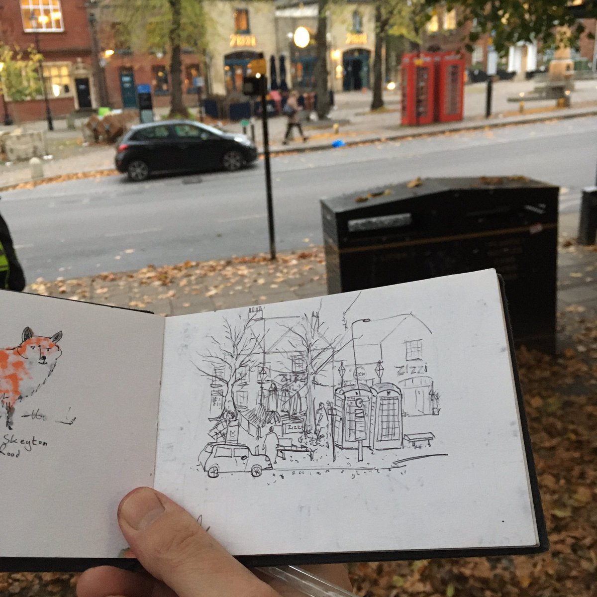 neildavison1969's tweet photo. Tombland sketchbook in hand drawing waiting for the bus. 
I can confirm that it’s not an actual tiny car and giant phone boxes, it’s just my dodgy drawing proportions. 
#dailydrawing #tomblandnorwich #sketchbook #Norwich #tinycar #ArtistOnTwitter #ArtistOnX #thedailysketch https://t.co/IaByn5c7Va