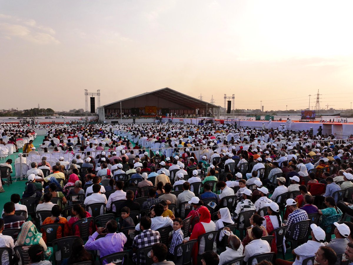 Gurudev's tweet image. A sea of people braved the afternoon heat in Surat and came together for music, wisdom, and meditation. A remarkable display of commitment and faith by the organisers, who ensured every convenience for the attendees.