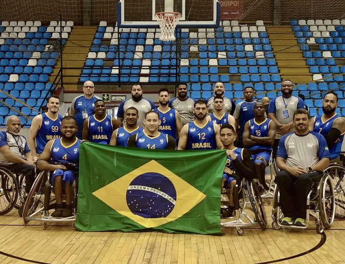 Seleção de basquete posa com a bandeira do brasil na quadra em Bogotá.