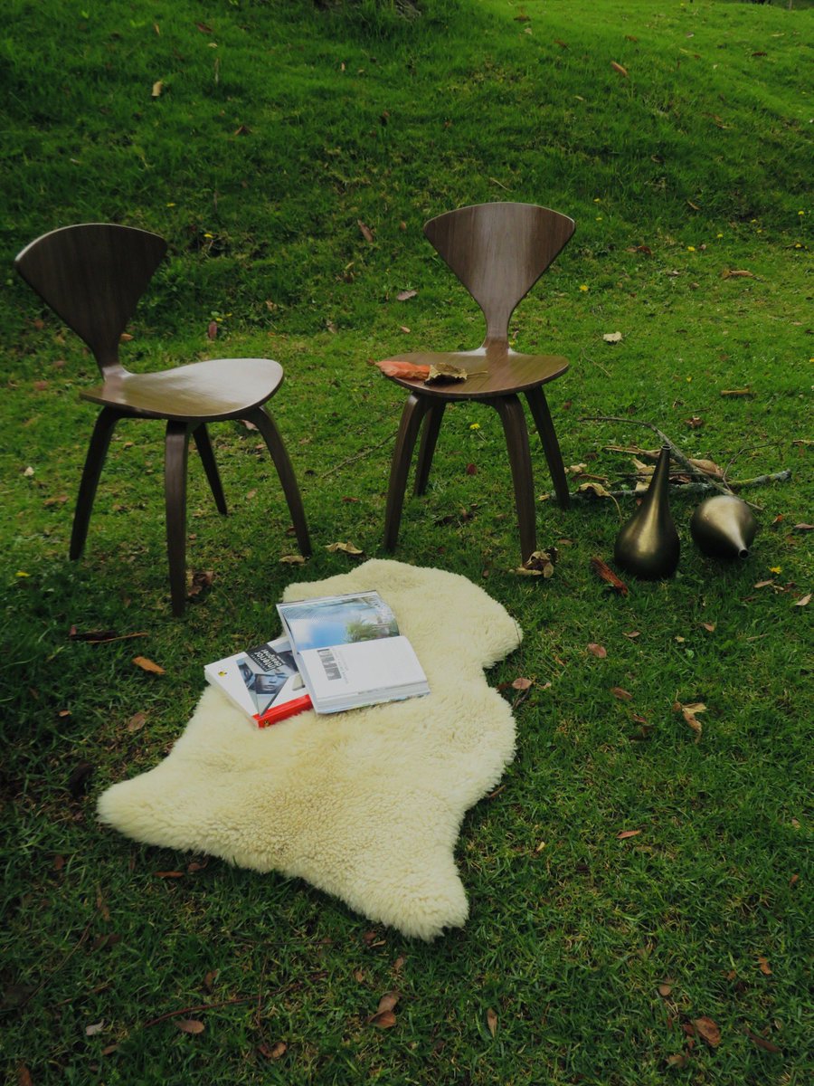 Silla de madera contrachapada moldeada con una elegante forma de reloj de arena curvado.