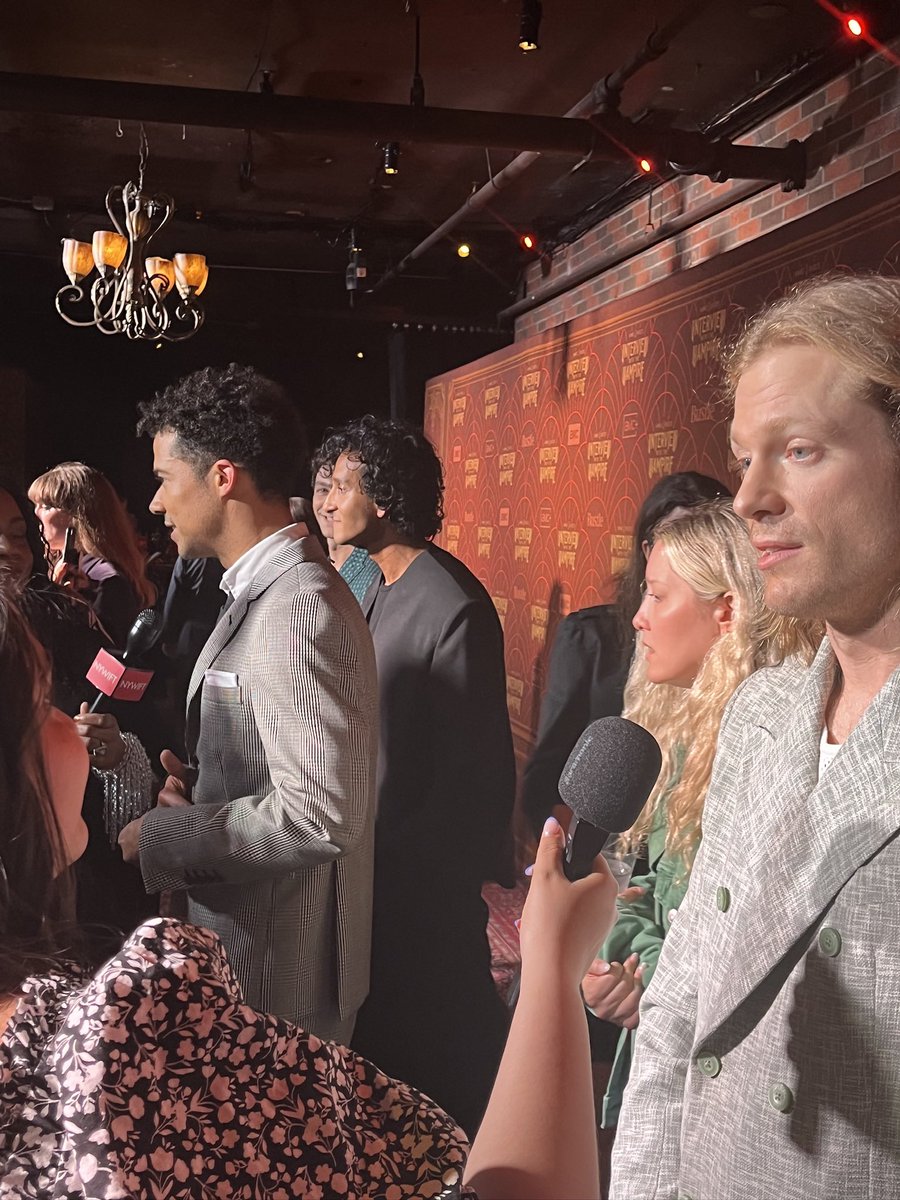 kellixboyle's tweet photo. it’s been an insane week &amp; today’s gonna suck so here’s a dopamine boost. @Moondancer1626 recently sent me this shot from the #IWTV premiere that i’m in the background of. look what’s happening behind me. unintentional devil’s minion version of S1 key art. serendipitous timing!! https://t.co/BVA1OR3gMF