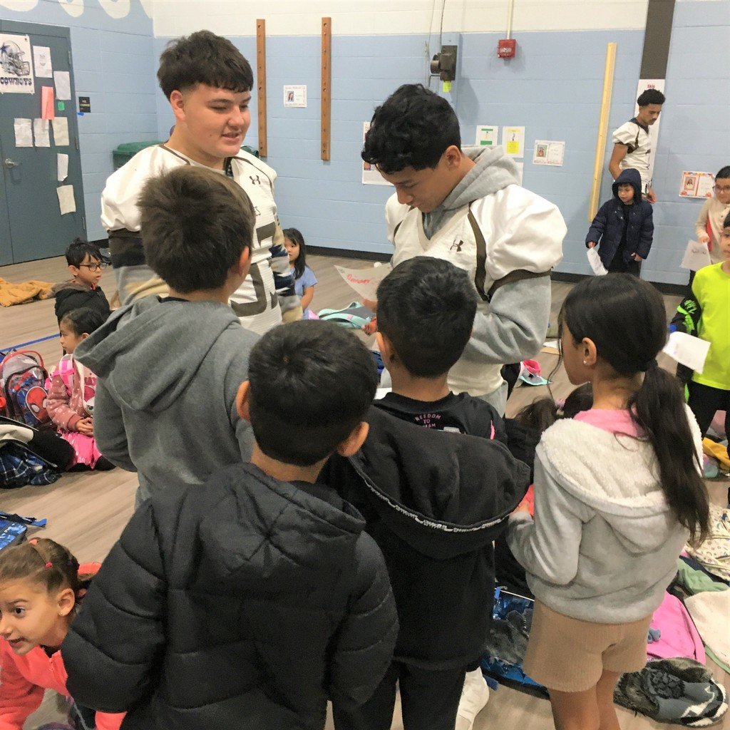 Garden City High School football players were at Gertrude Walker Elementary School this morning greeting students, giving Hi-5s, and signing autographs.
