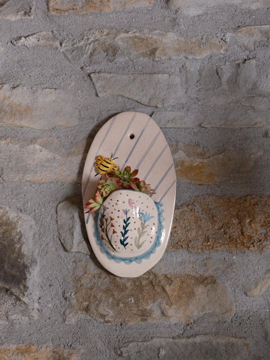🐝🌸 Brighten your walls with this handmade ceramic wall pot featuring floral details &amp; a cute bumblebee! Perfect for plants or as a decorative accent. 🌿

🛒 sofceramics.etsy.com/listing/180740…  #HandmadeDecor #Ceramics #WallArt #EtsyShop #giftsforher