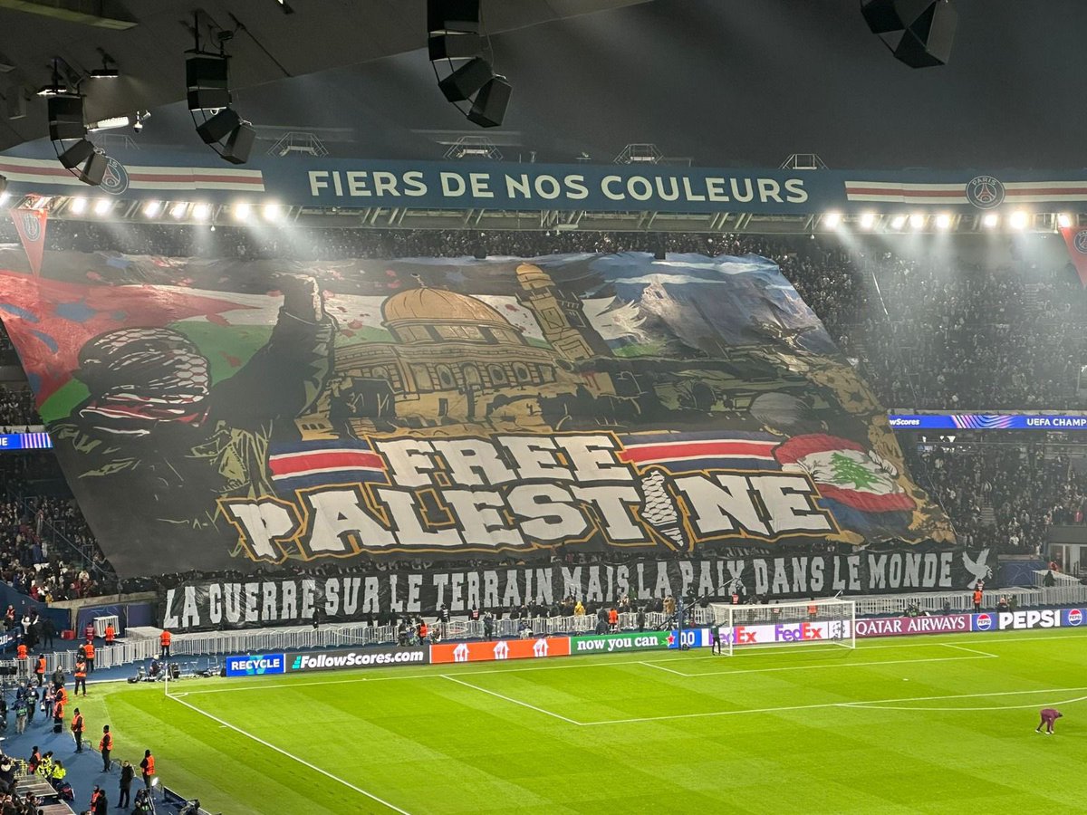 JeremBenhaim's tweet photo. Ce soir au Parc des Princes, lors du match opposant le PSG à l’Atlético de Madrid, le Collectif Ultra Paris a déployé un tifo « Free Palestine » avec en dessous le message suivant : « La guerre sur le terrain mais la paix dans le monde ».

Oui, enfin… si on regarde de plus près ce tifo, on peut voir à gauche un individu en keffieh, ressemblant étrangement soit à un membre du #Hamas, soit un pro-palestinien radical.

De plus, le « i » de « Palestine », représentant la carte d’#Israël, est entièrement recouvert d’un keffieh, une allusion évidente au fameux slogan « de la rivière à la mer ».

Les Ultras ont vraiment une très drôle conception de la paix avec #Israël…