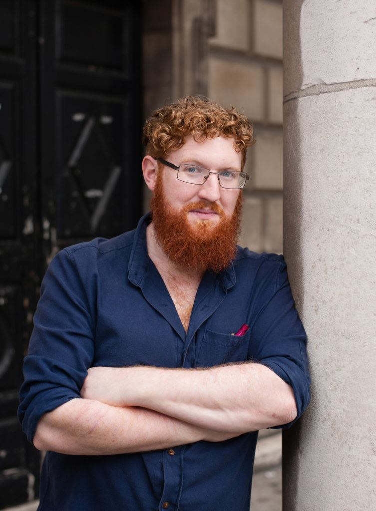 ucddublin's tweet photo. ✍️👨‍🎓 Gill Books signs deal for new series by acclaimed UCD Creative Writing graduate Dave Rudden  👏👏👏

A new series by a graduate of UCD's Creative Writing Masters is set for release next year following a two-book deal with Gill Books.

Venetia Gosling, a children’s publisher at Gill Books, has acquired the English-language rights outside of North America to Dave Rudden's latest work. Rudden is best known for his Knights of the Borrowed Dark trilogy.

The Cavan young adult author wrote the first chapter of the acclaimed series while undertaking the Master's Degree in Creative Writing at UCD in 2013 and is one of several notable graduates to come to national and international attention in recent years, including the 2024 Booker Prize nominee Colin Barrett.

Three of its graduates were also named on a list by the An Post Irish Book Awards, which showcases a new generation of talented Irish authors in Ireland ahead of this year’s Irish Book Awards.

His new series, Tales of Darkisle, debuts in 2025. The first novel, Conn of the Dead, will be released in May. The second book, Nell on Earth, will follow in early 2026.

The “spooky” new books are aimed at nine to twelve-year-olds and follow creatures from Irish folklore in a modern setting.

The synopsis of the first book reads: “Conn of the Dead follows 11-year-old serial miscreant Conn, who accidentally releases the Abhartach monster while poking around the UCD National Folklore Collection"

“A terrifying chase through the university ensues, as the bodiless sorcerer hunts Conn through every piece of technology it can find. Can Conn work out how to defeat the Abhartach before it regains its true power?”

As a Creative Fellow of UCD, Dave mentors various organisations, including Words Ireland and CBI’s Raising Voices – a national mentorship focusing on uplifting marginalised voices.

He was also recently Dublin City University’s Young People, Children and Education (YPCE) Artist in Residence, during which he delivered workshops as part of the Write to Read programme and Fighting Words, as well as did open day consultations for staff and students, and large-scale talks for local schools.

His Knights of the Borrowed Dark trilogy won the Best Senior Children’s Book of the Year at the Irish Book Awards in 2016 and was selected by the city of Dublin for its UNESCO-affiliated Reading Campaign for Children in 2017.