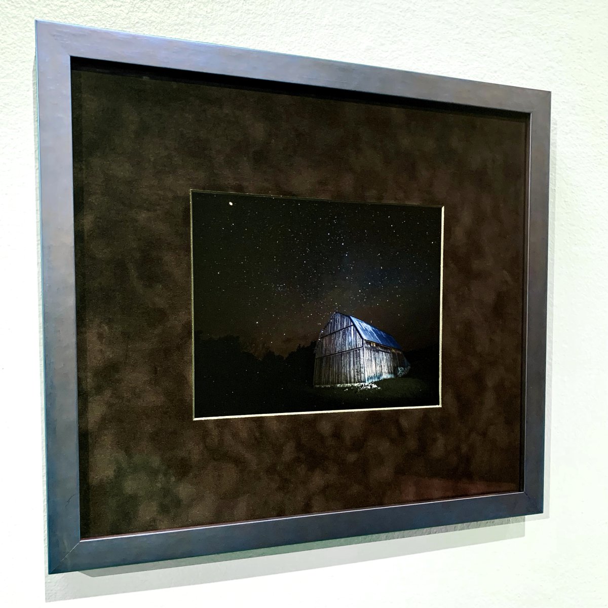 FramesUnlimited's tweet photo. Admiring the night sky, #FrameFridays. A photograph in remembrance of our client’s loved one’s talents, this piece displays a barn lit up under the #starry sky. Our team framed this #photograph in a dark blue metallic frame, a deep black suede mat, and museum glass. https://t.co/1W595rKBGB