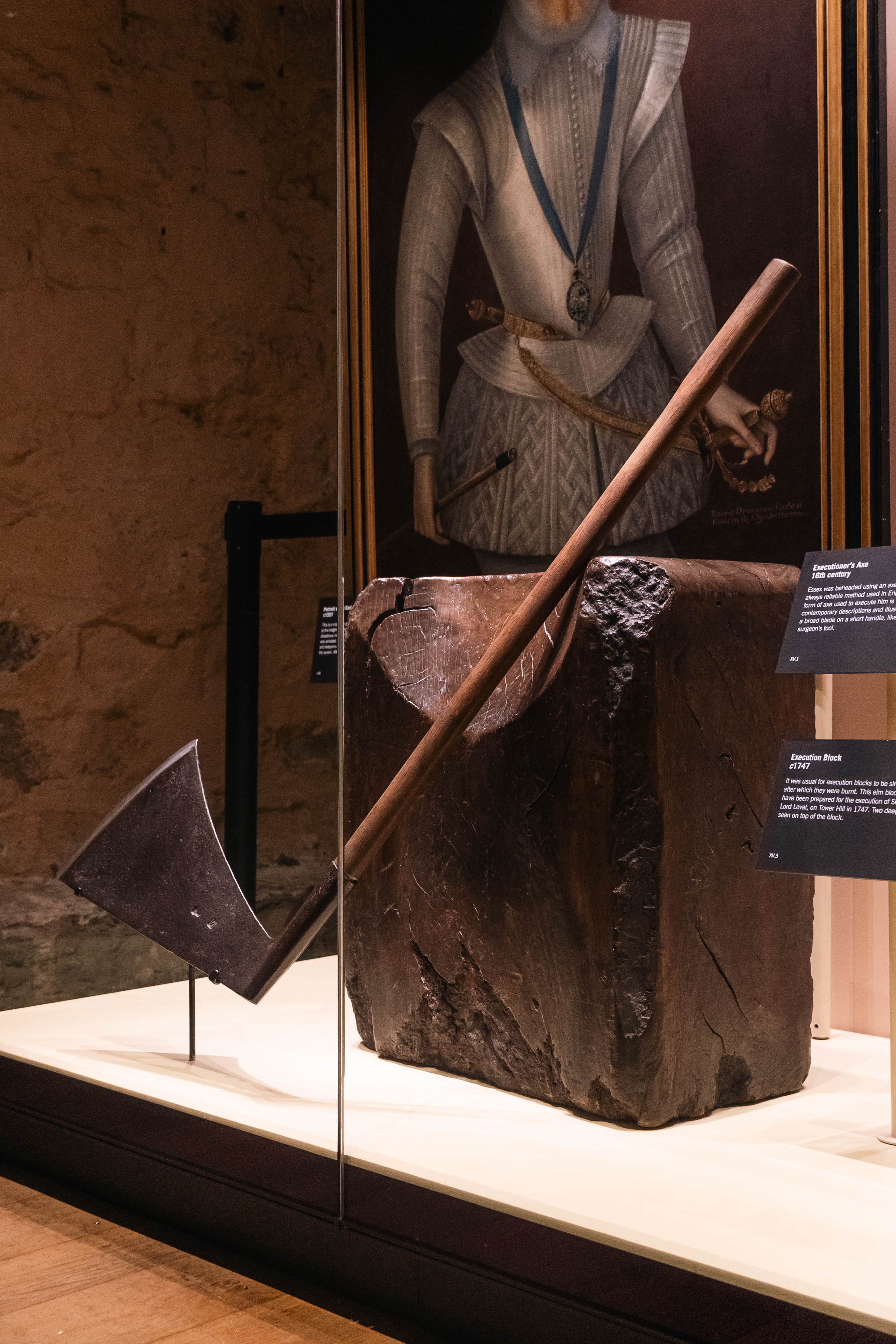 an axe resting on a block inside a display case