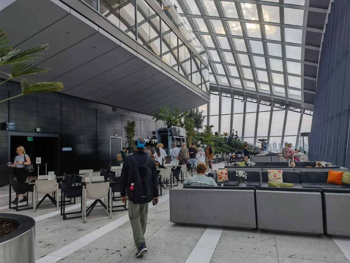 orientalli's tweet image. The interior of the Sky Garden featuring seating areas, visitors, and a view of the skyline through large glass panels.