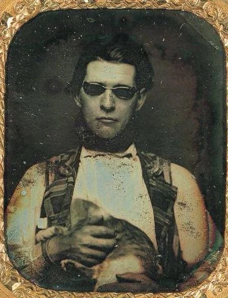 historyinmemes's tweet photo. Daguerreotype of a man wearing tinted glasses and holding a cat, c. 1850. https://t.co/bQjVyfjQT3
