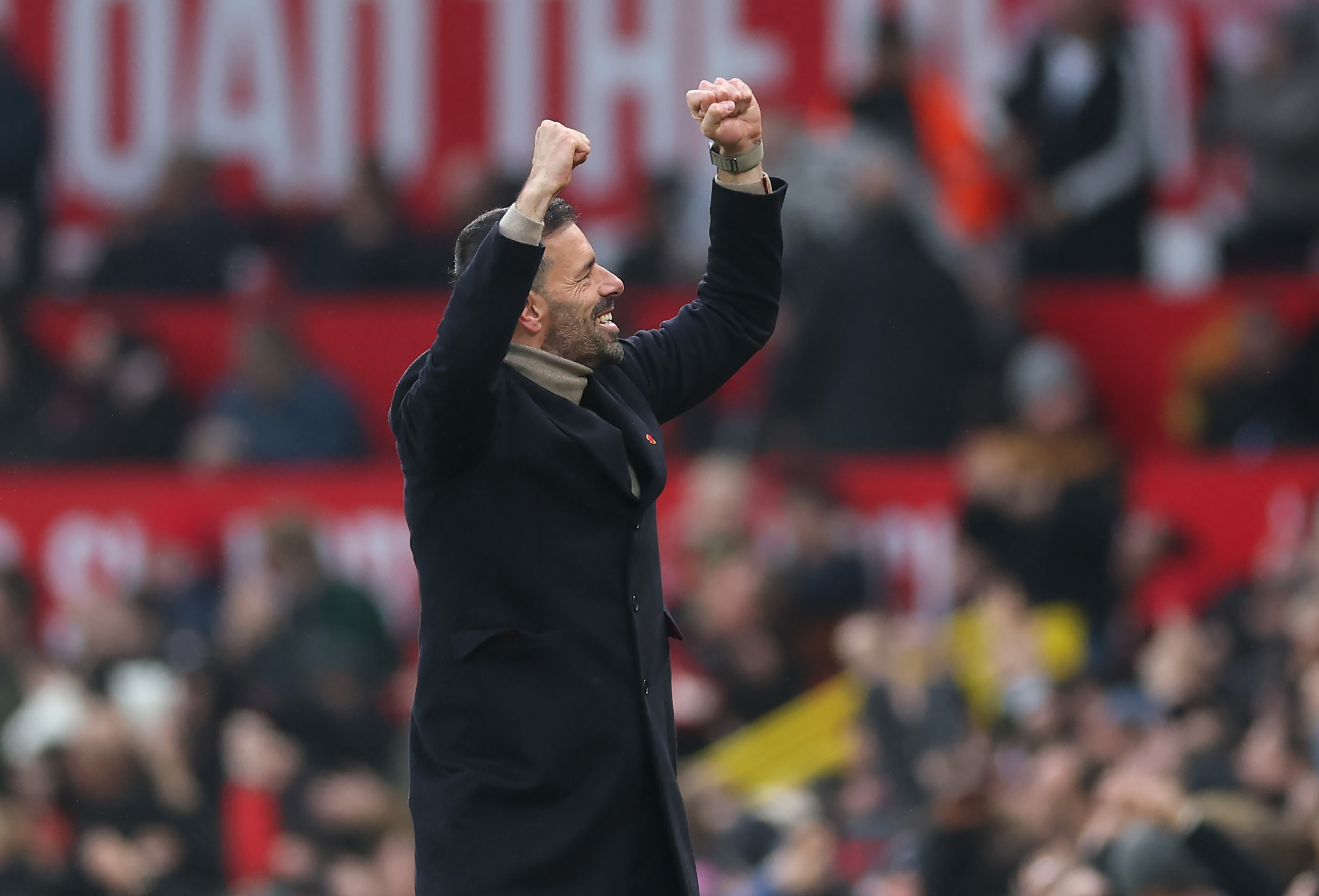 Ruud van Nistelrooy raises his arms in celebration after Bruno Fernandes's goal.