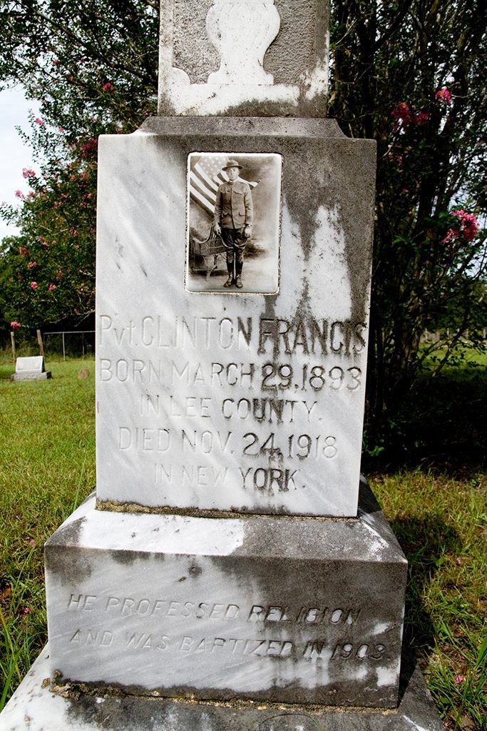 TracesofTexas's tweet photo. Every Veteran's Day, I recall this ceramic photographic that I found on a tombstone in a rural black cemetery near Giddings, Texas. The cemetery is so out-of-the-way and far removed that I doubt I could navigate back to it again. The inscription on the tombstone reads:

"Pvt. Clinton Francis
Born March 29, 1893
In Lee County
Died Nov. 24, 1918
In New York City
He professed religion and was baptized in 1903."

At first I thought that Private Francis must have died from wounds he received during World War I, but later I learned that he died in New York after contracting the Spanish Flu while aboard a ship that was bringing him back from France.

But look at him looking back at us though the generations! See how proud he is in his uniform and his gloves and his boots!  And I always think that it must have been hard for him to be in the service of a country that most likely treated him as a second class citizen.  After all, being a general is relatively easy:  generals get a nice bed and good food. But to be a black man on the lowest rung of the ladder and going to war and doing so with dignity all the while knowing that you'll be returning to a segregated Jim Crow society .... that takes courage.

So now to be remembered this day, the day that celebrates the sacrifices that he and so many others made so that we might live in freedom. Anybody who knew Private Francis is long gone and he is now just a forgotten man in a remote cemetery, a wisp of smoke through a keyhole,  dust blowing around a corner.
But I have not forgotten you, Private Francis. Every Veteran's day, I remember. And I raise my glass to you and to the uncountable others and offer only the hope that we not let our memories of you die.

May your spirit forever roam these sunlit prairies.