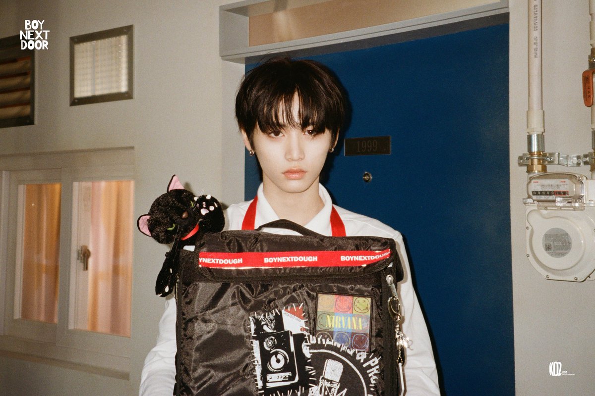 Arriving with serious vibes and a side of extra toppings. This pizza delivery guy isn’t just bringing the food—he’s delivering a mystery with every stare. With a bag full of patches, pins, and a black cat buddy, who knows what’s next on the menu? Your order just got intriguing.
