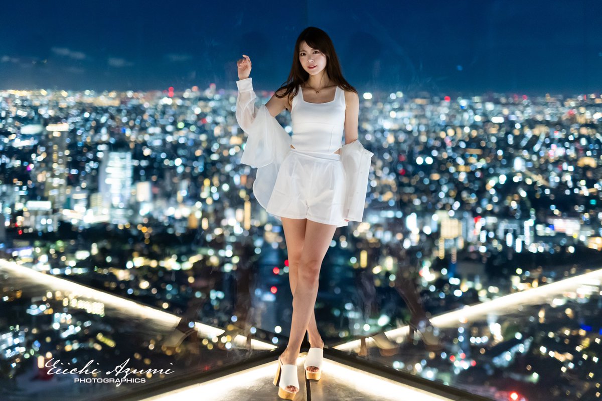 azumix_photo's tweet photo. ���景ポートレート

これからの季節、夜景やイルミネーションで撮ることも多いかと思いますが、自分が夜景ポートレート撮影する時に1番気をつけている事は、「背景の夜景との光の馴染ませ」「バランス」です

ストロボ使えば写ることは写りますが、被写体ばかりが明るくなり、背景の夜景は暗いという経験された方も多いかと思います。これは背景とのバランスがとれてない状態です

自分が夜景ポトレをする時に考える順番とポイントを説明します

①まず、地明かりを使うのか、光源を使うのか決める。表情重視の夜ストリートや都心のような光が溢れてるところは地明かりを使う事が多いです。真っ暗な場所で、カッコいいストリート感を出す時のみ、意図的にクリップオンストロボを使う事もあります

②光源を使う場合、LED光かストロボ��か決める（ストロボ光は強いので、淡い夜景は弱いLED光源にして夜景と馴染ませる）

③ストロボ光使う場合、ストロボはSS（シャッタースピード）の影響受けない瞬間光なので、背景の夜景をよりきちんと映したければ、手持ち撮影の限界までSSを��げる。足りなければISOを上げて夜景がきちんと写るまで調整する

④その状態でティフューズしたストロボ光を当てて被写体とのバランスをとる。TTLは使う事はなく、必ずマニュアルで出力を決め、ストロボ光を最小にしても明るすぎる場合は、被写体と光源との距離を空けて調整

⑤より立体感を出すため、２灯目のバックライトを入れて輪郭を作り「夜景と被写体の切り離し」をする。人は明るいところに目が行くので、個人的にはバックライト光を地面側に回り込ませたくないので、ローググリッドなどをつけて、出来るだけ細い光を当てる。背景スタンドの脚などが写り込むのは仕方なく、後からPhotoshopなどで消す

こんな感じで作品作りしてます

作例のモデルさん
1.羽瀬 萌さん（SHIBUYA SKY地明かり）
2.蘭野りょうこさん（SHIBUYA SKY LED光）
3.MIUさん（東京駅 ストロボ光）
4.鎌田ありささん（東京駅 ストロボ光）

夜景ポトレ、ストリート撮影の季節、気になる方はDMまで