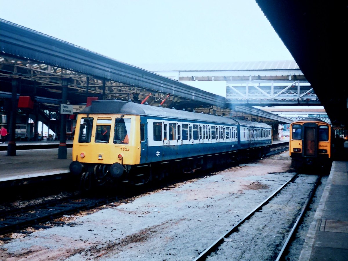 Invermuir's tweet image. Corporate Blue/Grey this week. Kicking off today, a bog triptych. T304, a shortened Pressed Steel class 117. Think it may have been the last blue/grey bog in operation. Exeter 1992 #tmrguk #BR #Class117.
