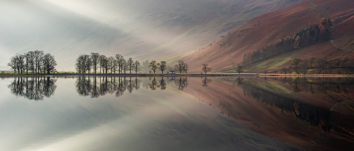 For a brief 15 mins at Buttermere, the Sun sent shafts of #light down and back lit the tees while illuminating the slopes on their right. 
The still air creating a great #reflection. 

#fsprintmonday #appicoftheweek
#photography #Landscapephotography
@CanonUKandIF #LakeDistrict