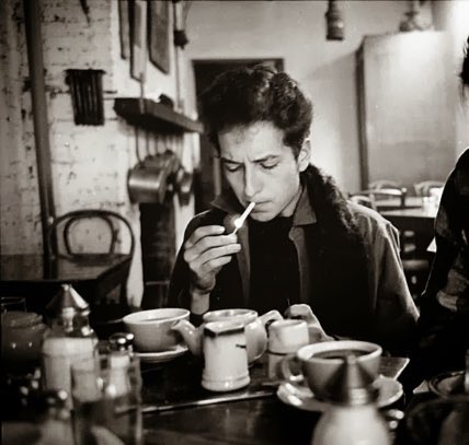 Bob Dylan lights a cigarette in a coffee shop, Greenwich Village, NYC, 1963. 📸: Jim Marshall. #BobDylan #Dylan
