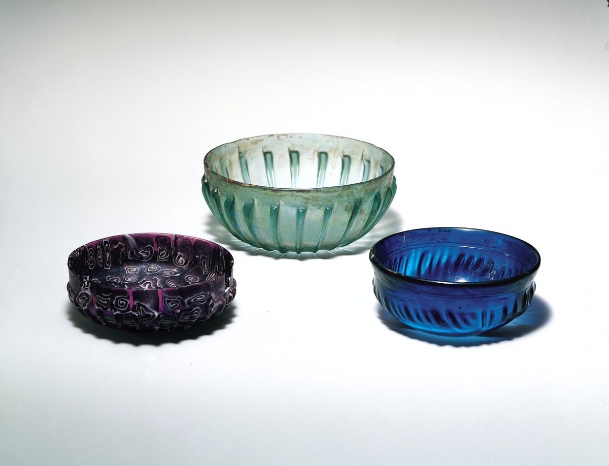 Three beautiful #Roman glass bowls (l-r) in a deep purple with white swirls, pale green-blue, &amp; a deep cobalt blue. All of them are about 2000 years old, &amp; would have been a very fashionable piece of tableware (📷 NY Met Museum) #Archaeology #RomanArchaeology #AncientGlass