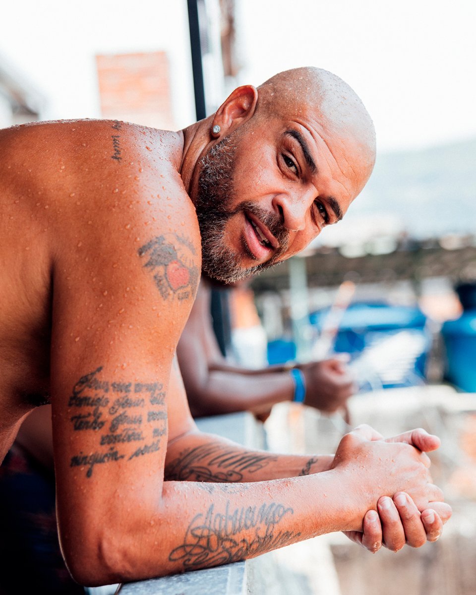 TPTBrasil's tweet photo. Adriano Imperador: “Repara que pra entrar e pra sair da Vila Cruzeiro tem que passar na frente do campo. O futebol se impõe na nossa vida. 

Aqui meu pai era feliz de verdade. Almir Leite Ribeiro. Pode chamá-lo de Mirinho, ele era conhecido assim por todo mundo. Um cara de conceito alto. Tô mentindo? Pergunta pra qualquer um. 

O Mirinho era um líder da Vila Cruzeiro. Todo mundo respeitava. E ele dava o exemplo. Futebol era com ele. Uma das missões do Mirinho era evitar que a molecada se envolvesse com o que não devia. Ele tentava sempre trazer as crianças pra bola. Não queria ninguém de bobeira. Muito menos vacilando na escola. O pai dele bebia muito. Esse, sim, era alcoólatra. Morreu disso, inclusive. Então, toda vez que via a molecada tomando uma, meu pai não tinha dúvida. Lançava copos e garrafas que estavam pela frente no chão. Mas não adiantava, né? Então, a fera mudou de tática. Quando a gente se distraía, ele arrancava a dentadura e colocava no meu copo, ou no dos meninos que estavam comigo. O cara era danado. Que saudades dele… 

Todas as lições que aprendi com meu pai foram assim, nos gestos. Não tínhamos conversas profundas. O velho não era de filosofar nem de ficar dando lição de moral, não. A retidão no dia a dia e o respeito que os outros tinham por ele era o que mais me impressionava.  

A morte do meu pai mudou a minha vida pra sempre. Até hoje é um assunto que ainda não consegui resolver. E pra tu ver como são as coisas, a merda toda começou aqui, na comunidade que eu considero tanto. 

A Vila Cruzeiro não é o melhor lugar do mundo. Muito pelo contrário.

Porra, meu pai tomou um tiro na cabeça em uma festa no Cruzeiro. Bala perdida. Ele não tinha nada a ver com a confusão. A bala entrou pela testa e ficou alojada na nuca dele. Os médicos não tinham como remover. Depois disso, a vida da minha família nunca mais foi a mesma. Meu pai passou a ter convulsões frequentes. 

Tu já viu uma pessoa sofrendo um ataque epiléptico na tua frente? Ah, então não queira ver, negão. 

É assustador.”