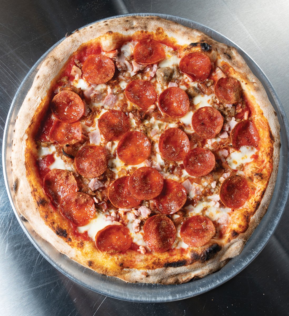 Solo Pizza’s meat-lovers’ pie, with its piles of sizzling, crackling pepperoni, sausage, bacon, and ham, is not to be eaten, well … solo. ow.ly/N1Ul50U547z