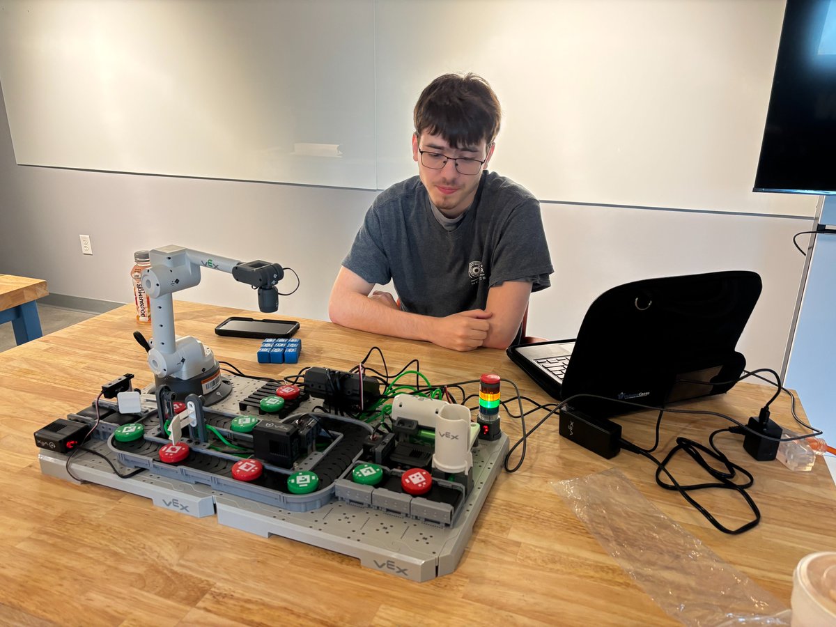 TechnologyBCS's tweet image. BCHS Senior, Denny Gardner and @PIE_Center_BCS Mechatronics teacher Dak Keylon work to create an automated sorting program on a VEX CTE Workcell, as a part of the Motor Controls and Practicum classes. This equipment is on loan from the new BCS STEM Hub lending library. #STEMHub