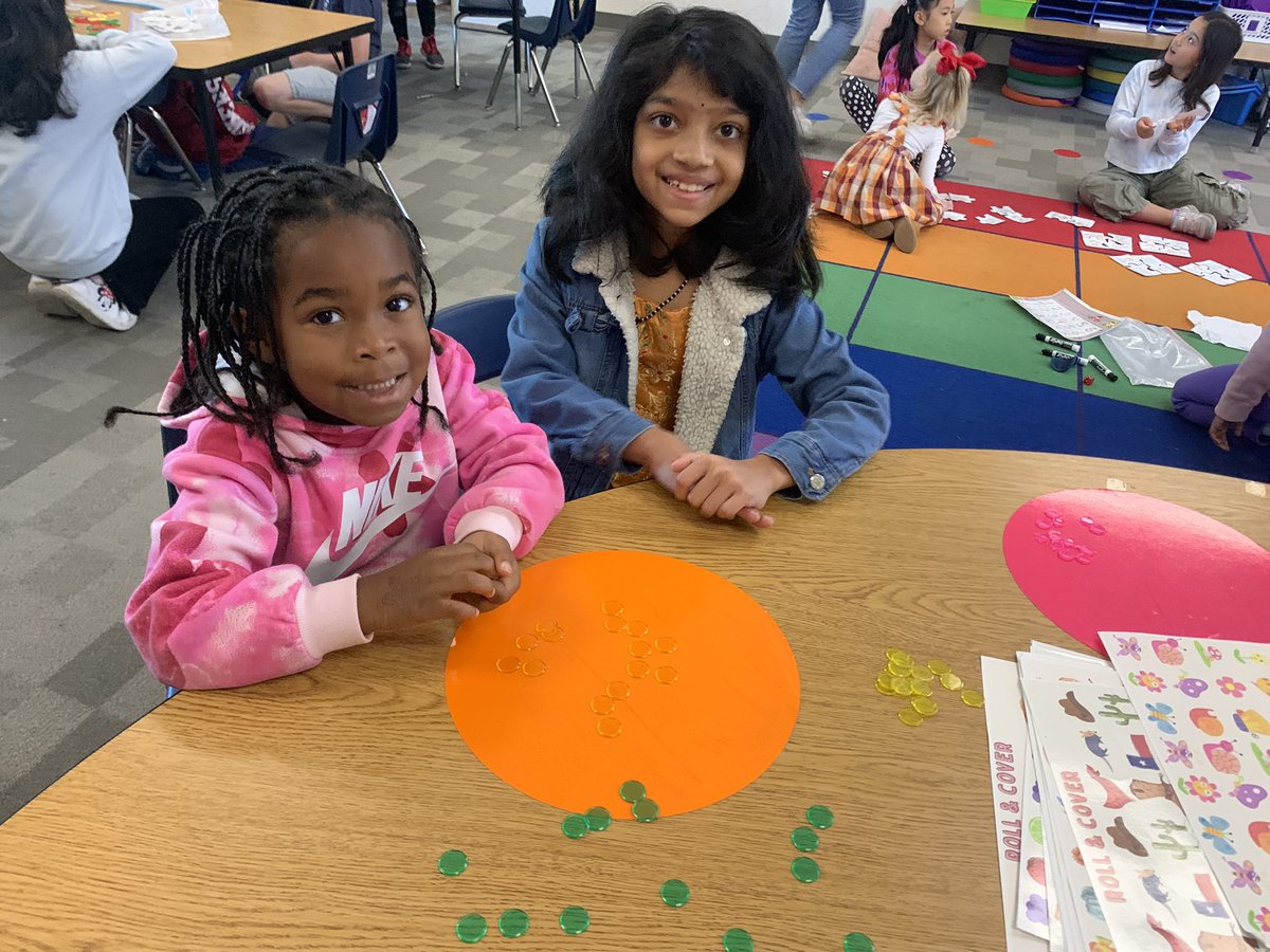 Third grade mentoring kindergarten during math stations.