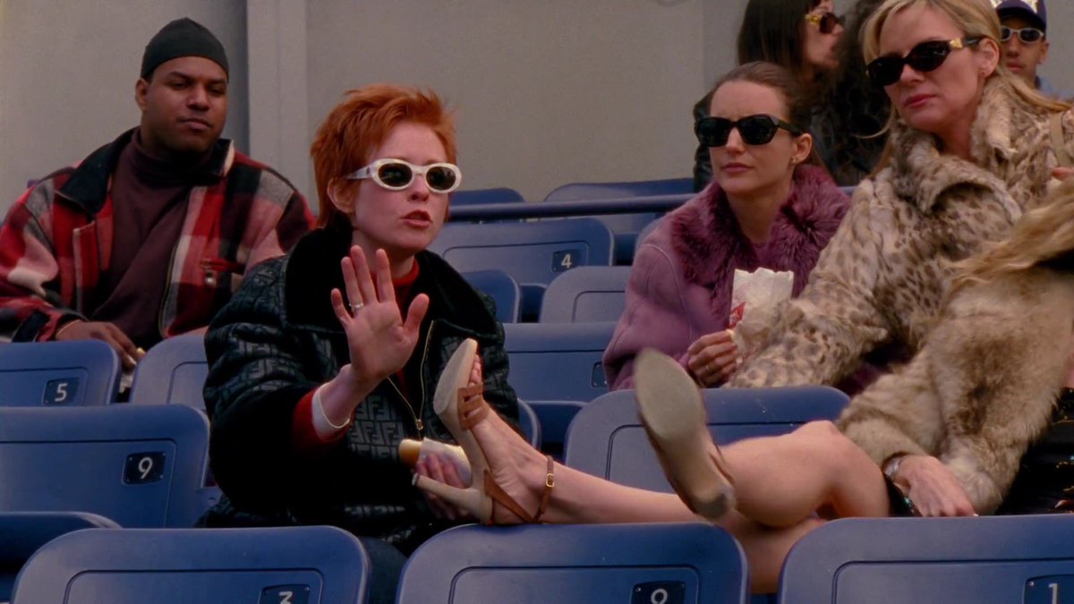 dumbandfunn's tweet photo. Miranda Hobbes wearing a gorgeous classic Fendi trench coat while taking her friends to a baseball game (to distract from Carrie’s latest heartbreak, of course) https://t.co/pqYmlGwtkz