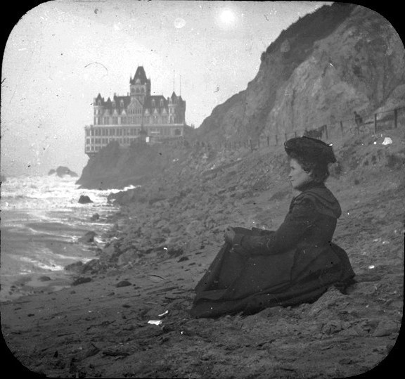 A woman staring at the sea in front of Cliff House, San Francisco. Photographed in 1900.