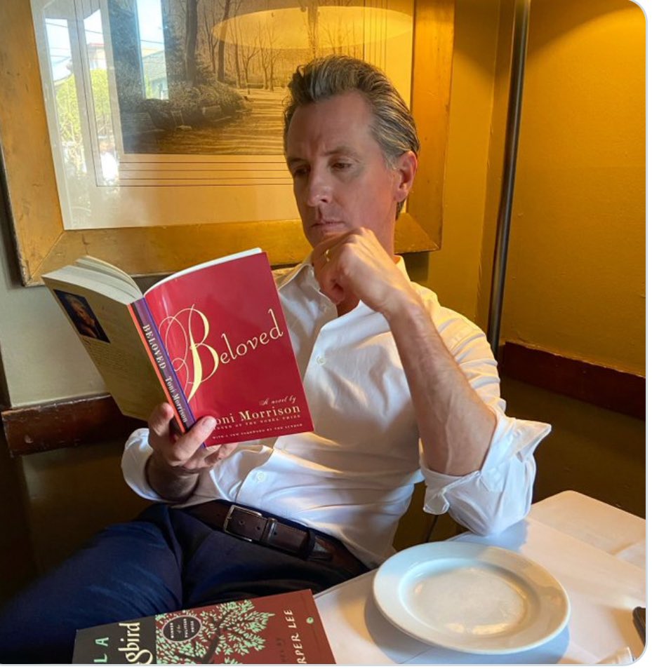 In the past week, a particular photo has been recirculating in certain corners of the internet. It features Gavin Newsom, California’s governor, leisurely reading Toni Morrison’s “Beloved.”
In the carefully staged picture, Newsom’s attention is fixed on the book (oh, he’s