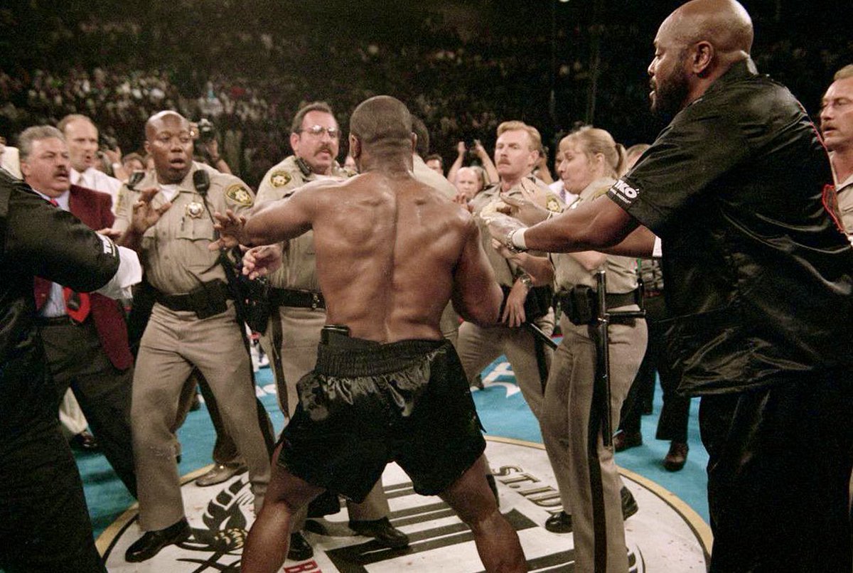 VegasIssues's tweet photo. Las Vegas police facing Mike Tyson after he'd just bitten Evander Holyfield's ear off. (1996) https://t.co/7Krn5g44Ym