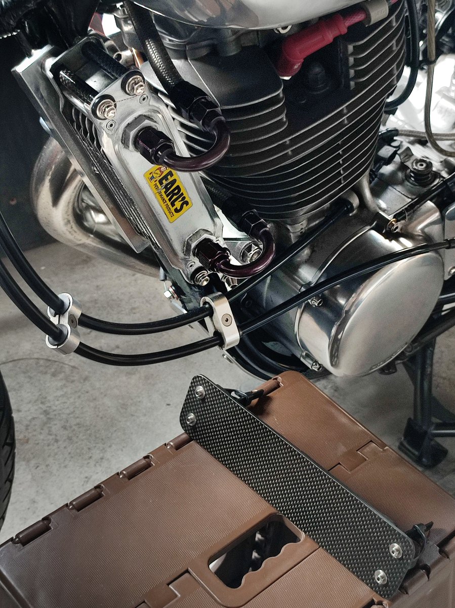 alfatact's tweet photo. 愛車のヤマハSR。今年も気温が下がってきたのでオイルクーラーに毎年恒例のカバーを付けます。カバーとクーラーのサイドパイプはトガシエンジニアリングにて購入したカーボン素材から制作。特徴的なU字型フィッティングは転倒時にも問題無かったですし走行中に触りやすくコア効果の温度確認も楽しい😆 https://t.co/tyLBHNm2tP